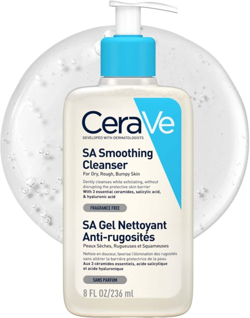 A bottle of CeraVe SA Smoothing Cleanser with a pump, placed in front of a clear soap or water. The bottle is mainly white with blue accents.