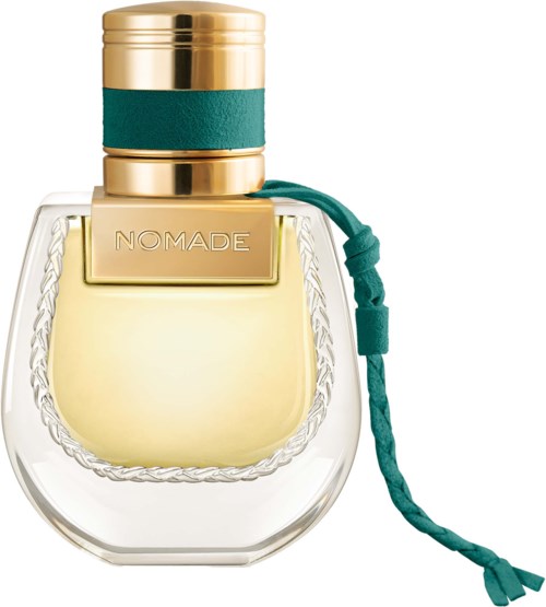 Een doorzichtige parfumfles met een goud- en groen deksel, en een teal vlag, met 'NOMADE' erop.
