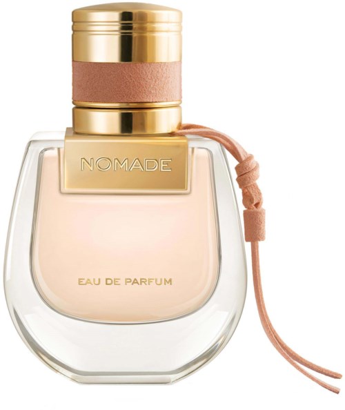 Een parfumfles met een goudkleurige en roze dop, gemerkt 'NOMADE', met een beige vloeistof en een roze koord.