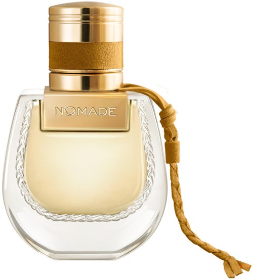 Een duidelijke glazen parfumfles met gouden dop, een gouden band en een geknoopt leerkoord. Het label zegt 'NOMADE'.
