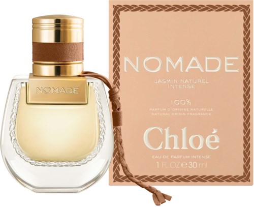 Een parfumfles met een gouden en bruine dop naast een roze doos met witte tekst, gemarkeerd 'NOMADE CHLOÉ.'