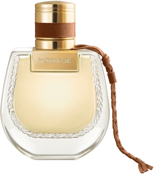 Een parfumfles met gouden dop, doorzichtige glazen body, bruin leren band en 'NOMADE'-label.