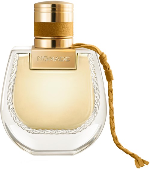 Een parfumfles met gouden dop, doorzichtige glazen fles en een gouden label met 'NOMADE'.