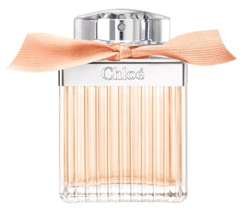 A clear glass perfume bottle with a peach-colored ribbon, featuring vertical lines and a silver cap, labeled 'Chloé'.