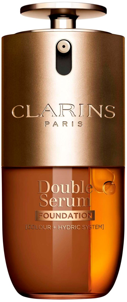En Clarins Paris-fondationsflaske med gullhette, gjennomsiktig oransje væske inni, og logo på forsiden.