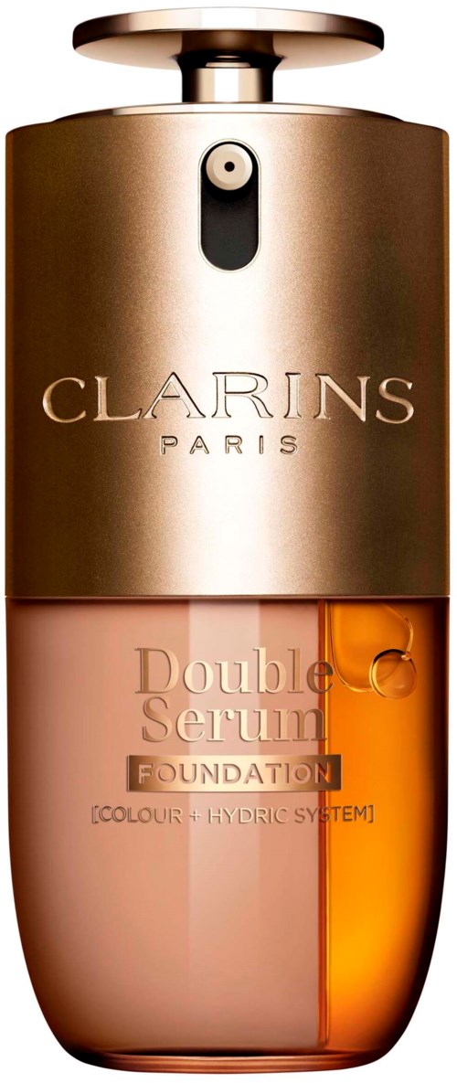 En Clarins foundation-flaske med metallkork og oransjeaktig væske inni.
