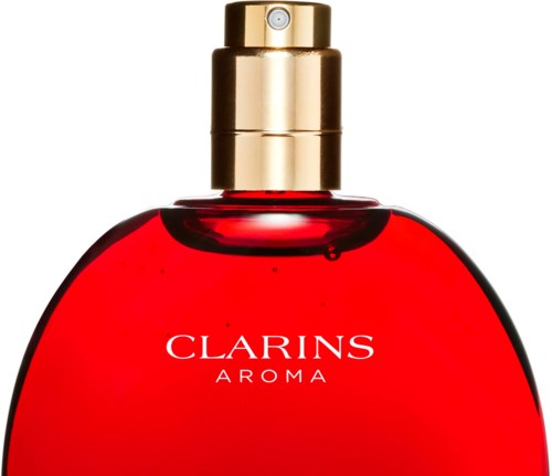 En röd parfymflaska med guldspraylock, märkt 'Clarins Aroma'.