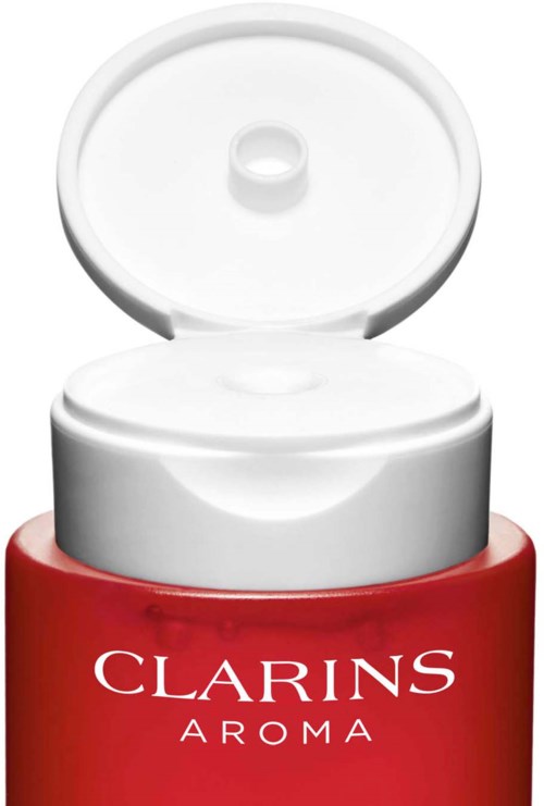 Een rood doosje met witte tekst, en een wit deksel open, gelabeld "Clarins Aroma."