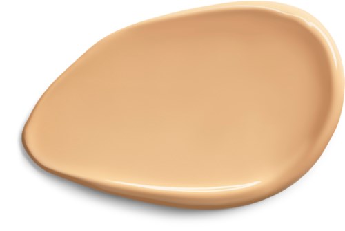 En beige, tårformad klick av kräm eller lotion på en vit bakgrund.