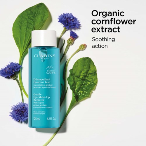 A blue bottle of gentle eye makeup remover with green leaves and blue flowers around it, with text about organic cornflower extract.