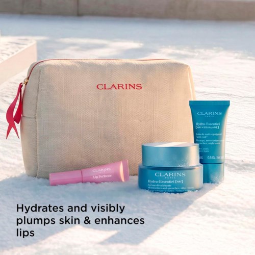 A skincare set with a beige bag, blue jars, and pink tube, placed on snow with a beach background.