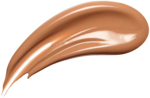 A swirl of beige-colored liquid makeup or foundation with a shiny, smooth texture.