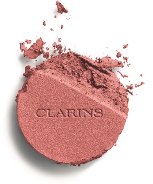 A round pink blush with the brand name Clarins embossed, some powder scattered around it.