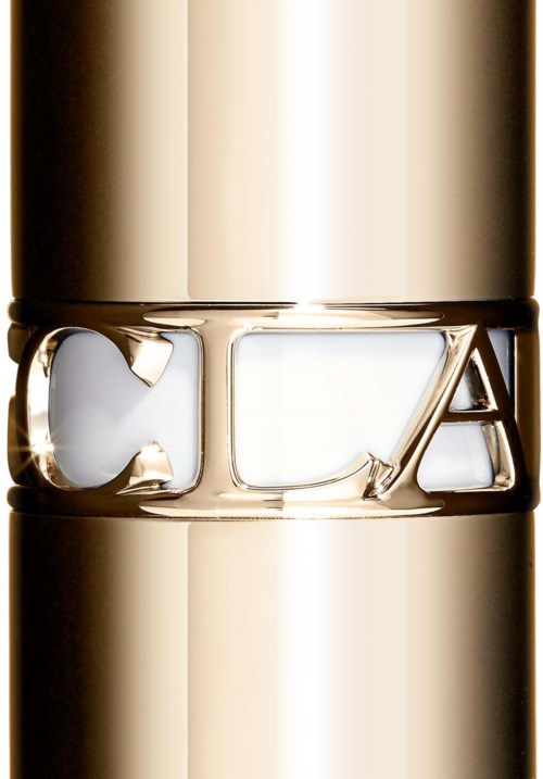 A close-up of a shiny, golden cosmetic bottle with the brand name 'Huda' engraved around it.