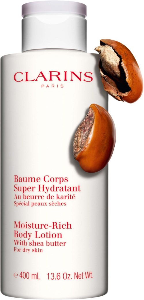 Een witte fles Clarins lichaamslotion met een gebroken karamelsnoepje ernaast.
