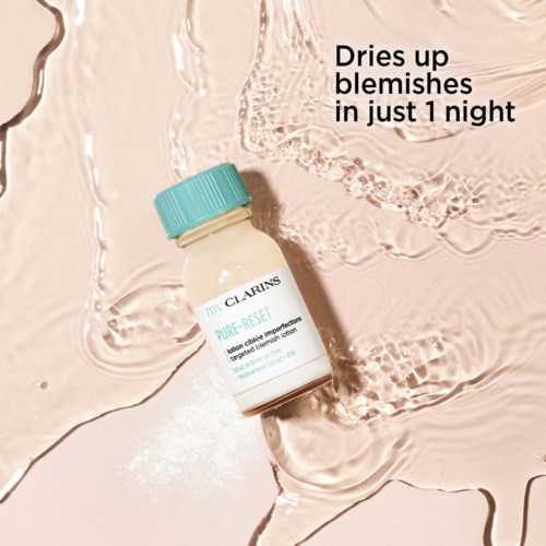 Pieni pullo, jossa lukee 'Clarins Pure Reset', makaa vaaleanpunaisella kostealla, teksturoidulla pinnalla. Teksti sanoo, että se kuivattaa epäpuhtauksia yön aikana.