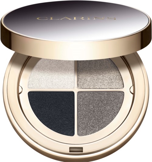 A round makeup compact with four silver and gray eyeshadows inside, topped with a gold lid that says 'Clarins'.