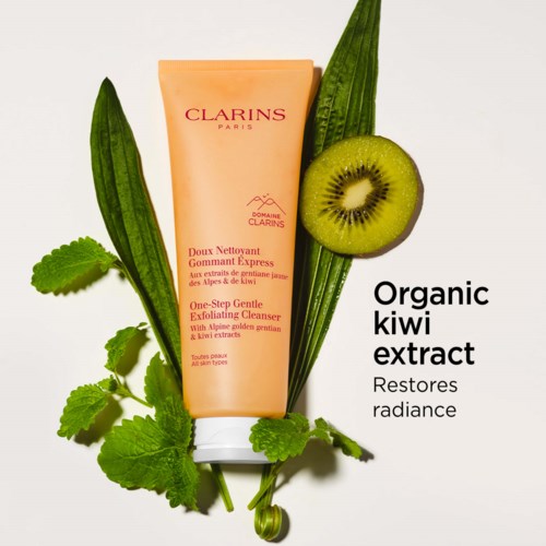 Clearing product with a peach-colored bottle, surrounded by green leaves and a sliced kiwi showing its interior.