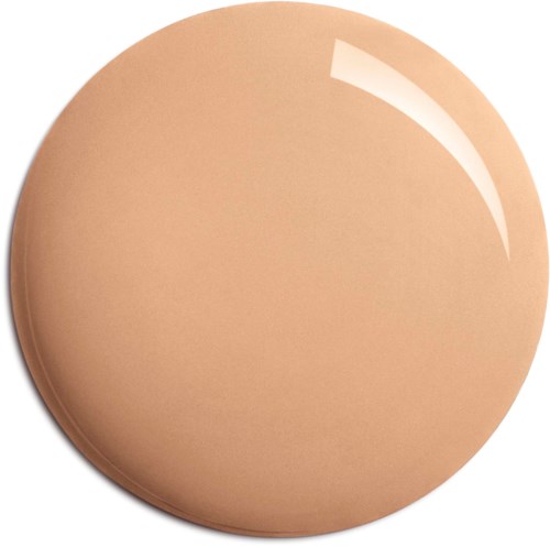 A round, beige makeup compact with a shiny surface and a slight reflection of light.