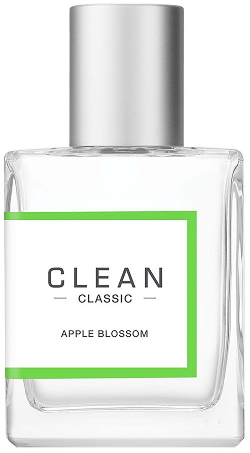 Een doorzichtige glazen fles parfum met zilveren dop, gelabeld 'CLEAN CLASSIC APPLE BLOSSOM' met groene rand.
