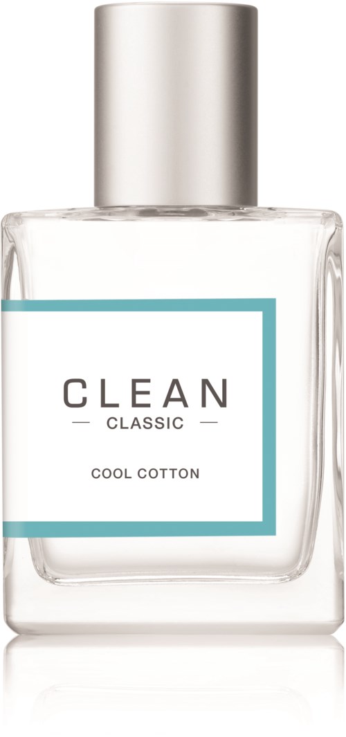 Een heldere glazen fles met een zilveren dop, gelabeld 'CLEAN CLASSIC COOL COTTON,' waarschijnlijk parfum of spray.