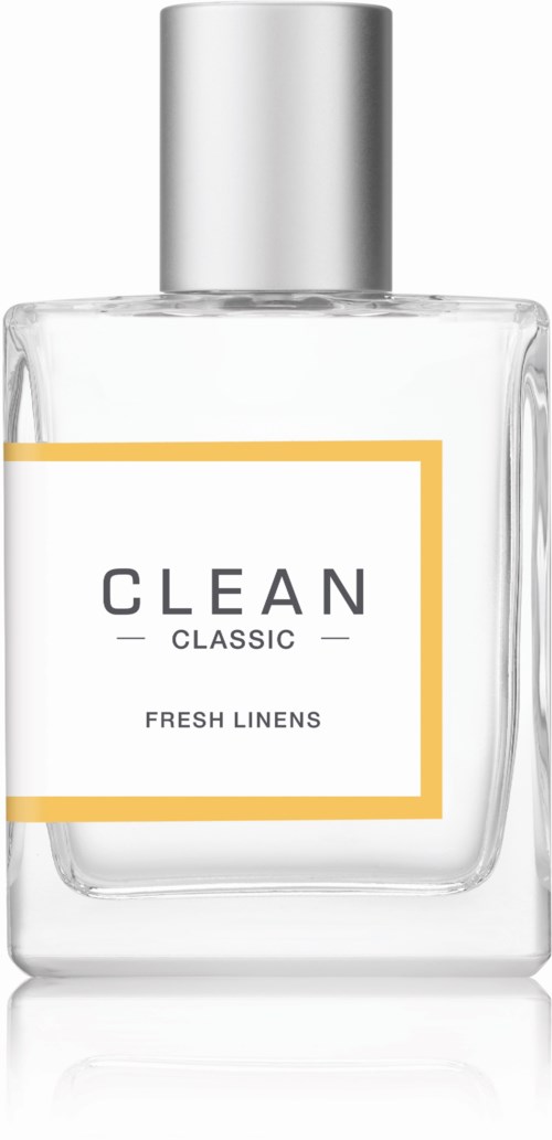 Een duidelijke glazen fles met zilveren dop, labelt met 'CLEAN CLASSIC FRESH LINENS'.