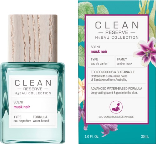 Een parfumfles en doos met een witte label, roze tekst en bloemenontwerp op de achtergrond.
