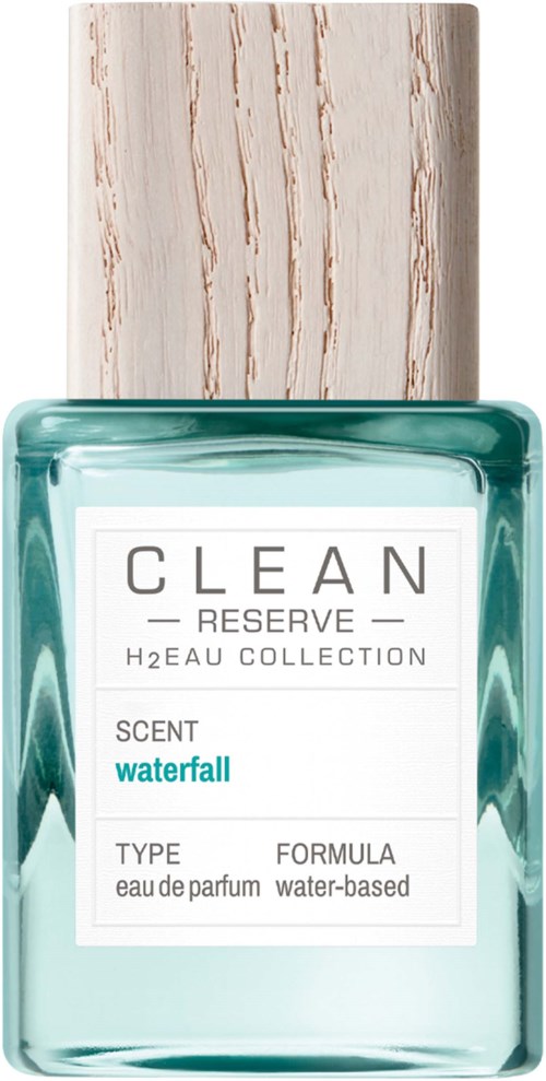 Een parfumfles met houten dop en een wit label met 'CLEAN RESERVE WATERFALL'.