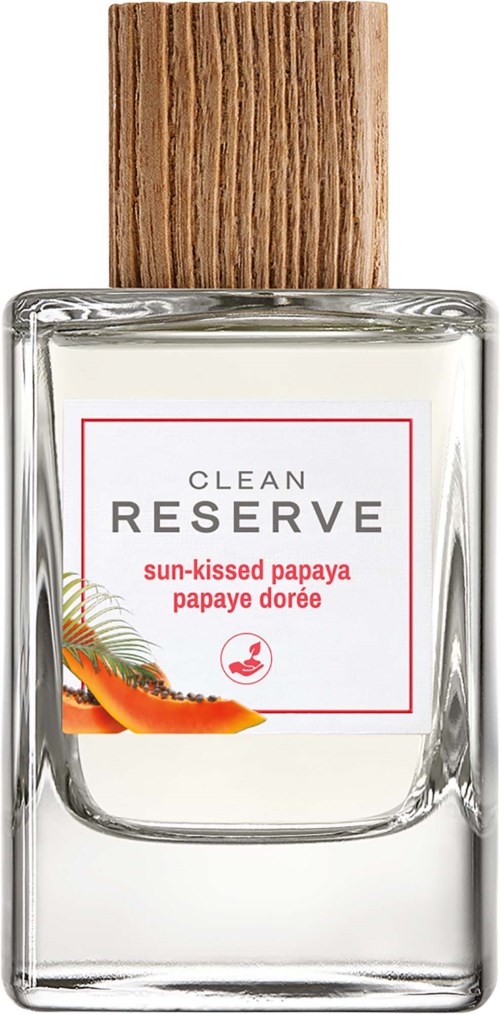 En klar glasflaska med en trähätta, med etikett för Clean Reserve solkysst papaya parfym, med en papayabild.