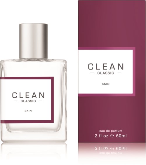Een parfumfles en doos met label "CLEAN CLASSIC SKIN," met zilveren dop en een paarse en witte doos.