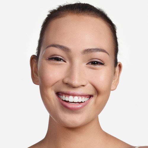 A woman with a bright smile, clear skin, and hair pulled back, looking happy and confident.