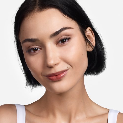 A young woman with short black hair smiling gently with neutral makeup.