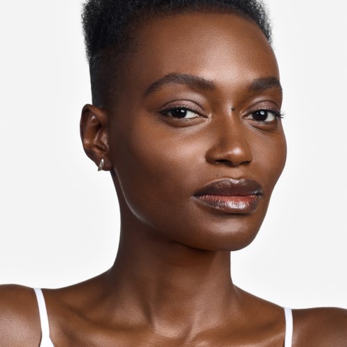 A woman with short hair, wearing a white top, looking confidently at the camera.