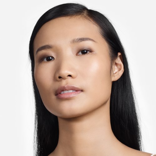 A young woman with long black hair, clear skin, and a neutral expression, looking slightly to the side.