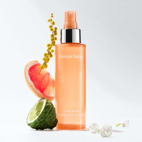 Een perzikkleurige flesje Clinique body spray met citroen, grapefruit en bloemen eromheen.