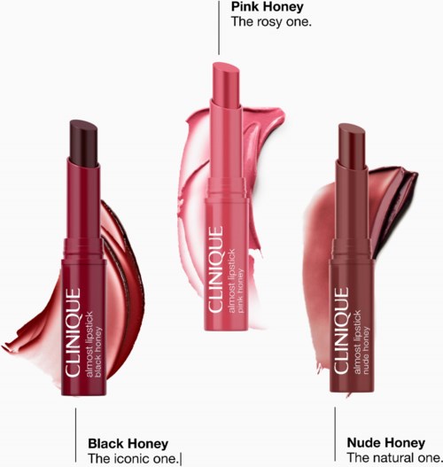 Three Clinique lipsticks with honey-inspired shades labeled Black Honey, Pink Honey, and Nude Honey, with smudges of lipstick colors.