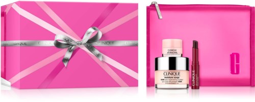 A pink gift box with a silver ribbon, next to a pink cosmetic bag containing skincare and lip products.