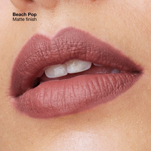 Close-up van lippen met matte, roze-beige lipstick, licht geopend en tanden zichtbaar.