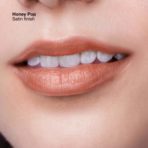 Close-up of lips with peach-colored lipstick and white teeth, smiling gently.