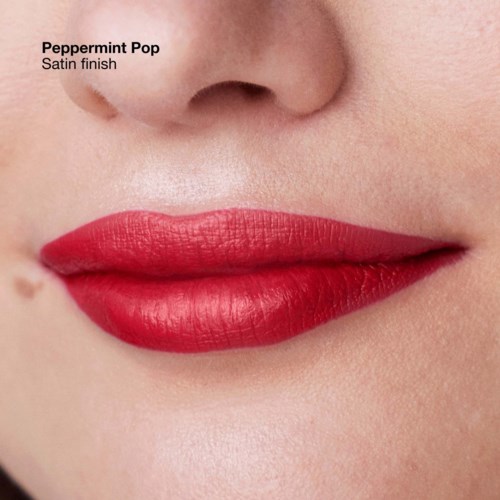 Close-up of lips with shiny red lipstick, part of a face showing the nose and skin texture. Text mentions 'Peppermint Pop' lipstick.