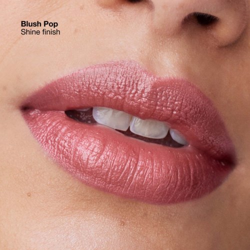 Nahaufnahme von Lippen mit pinkem Lippenstift, leicht geöffnet, zeigt Zähne und einen Hauch Zunge.