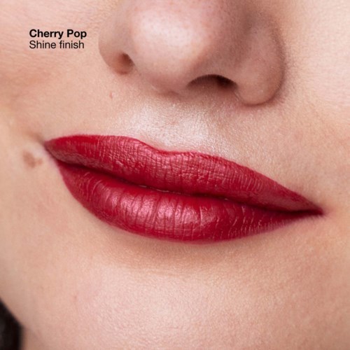 Close-up van lippen met felrode lippenstift genaamd Cherry Pop, glanzende finish, en gladde huid in de buurt.