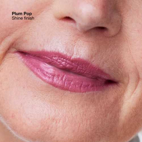 Close-up van lippen met roze lipstick getiteld 'Plum Pop Shine finish' op huid met zichtbare rimpels en poriën.