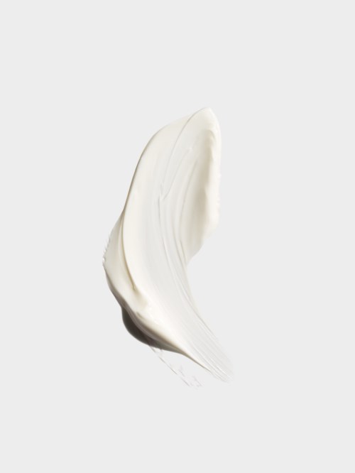 A white cream or lotion smear on a white background.