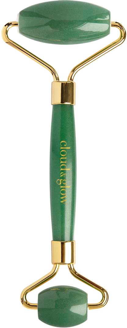 Een groene gezichtsroller met gouden accenten, gebruikt voor huidverzorging en massage.