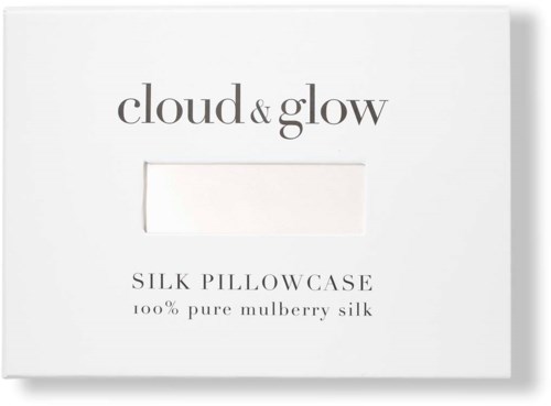 Een witte doos met zwarte tekst, noemt een zijden kussenhoes gemaakt van 100% pure moerbeizijde, door cloud & glow.
