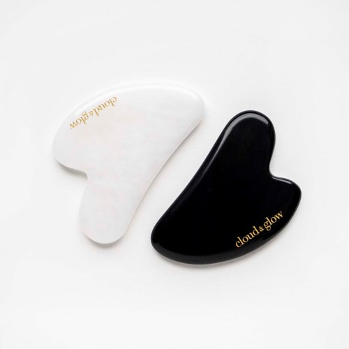 Twee druppelvormige objecten, een wit en een zwart, met gouden tekst "cloud&glow."