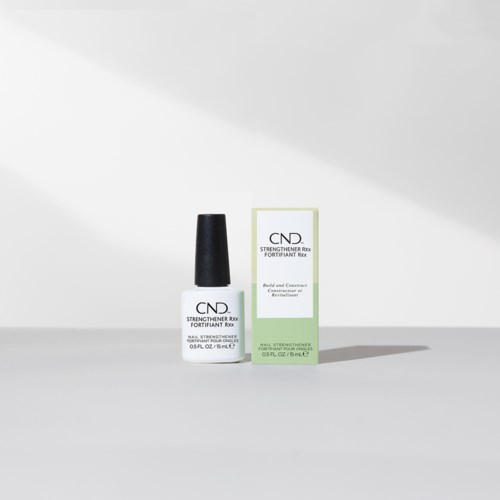 Een nagelversterker met witte fles, zwarte dop en groene en witte doos.