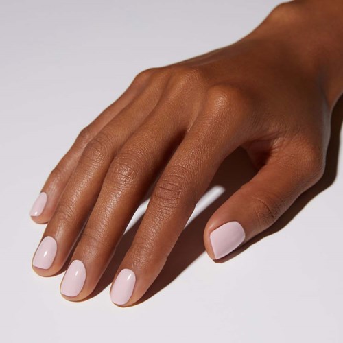 Goed verzorgde hand met lichtroze nagels op witte achtergrond.