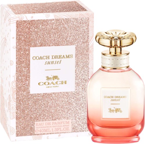 A pink perfume bottle with a gold cap and a matching box labeled Coach Dreams Sunset.